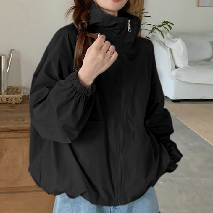 바람막이를 작게 접어서 에코백 옆 주머니에 간편하게 수납하는 모습