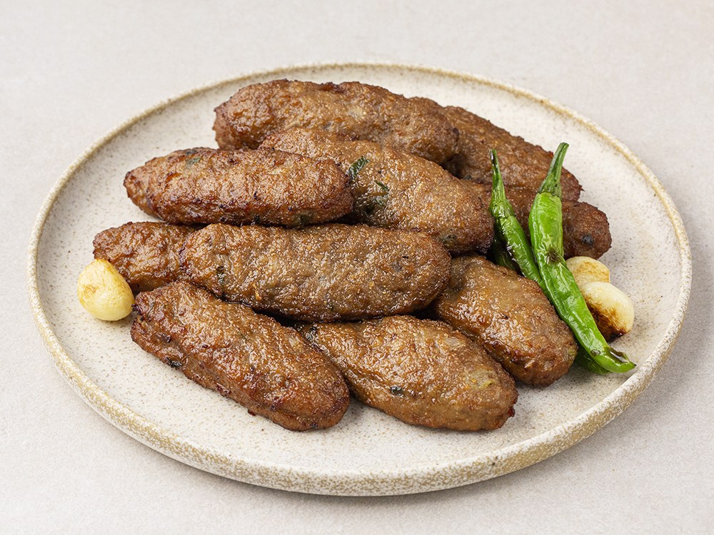 떡갈비를 반으로 잘랐을 때 보이는 선홍빛 명란 알갱이와 꽉 찬 고기 단면