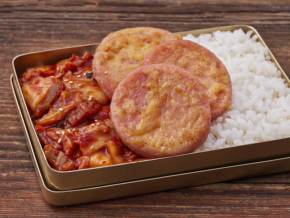 접시에 정갈하게 담긴 소시지 단면, 촉촉한 속살과 노릇한 겉면이 대비되는 근접 샷