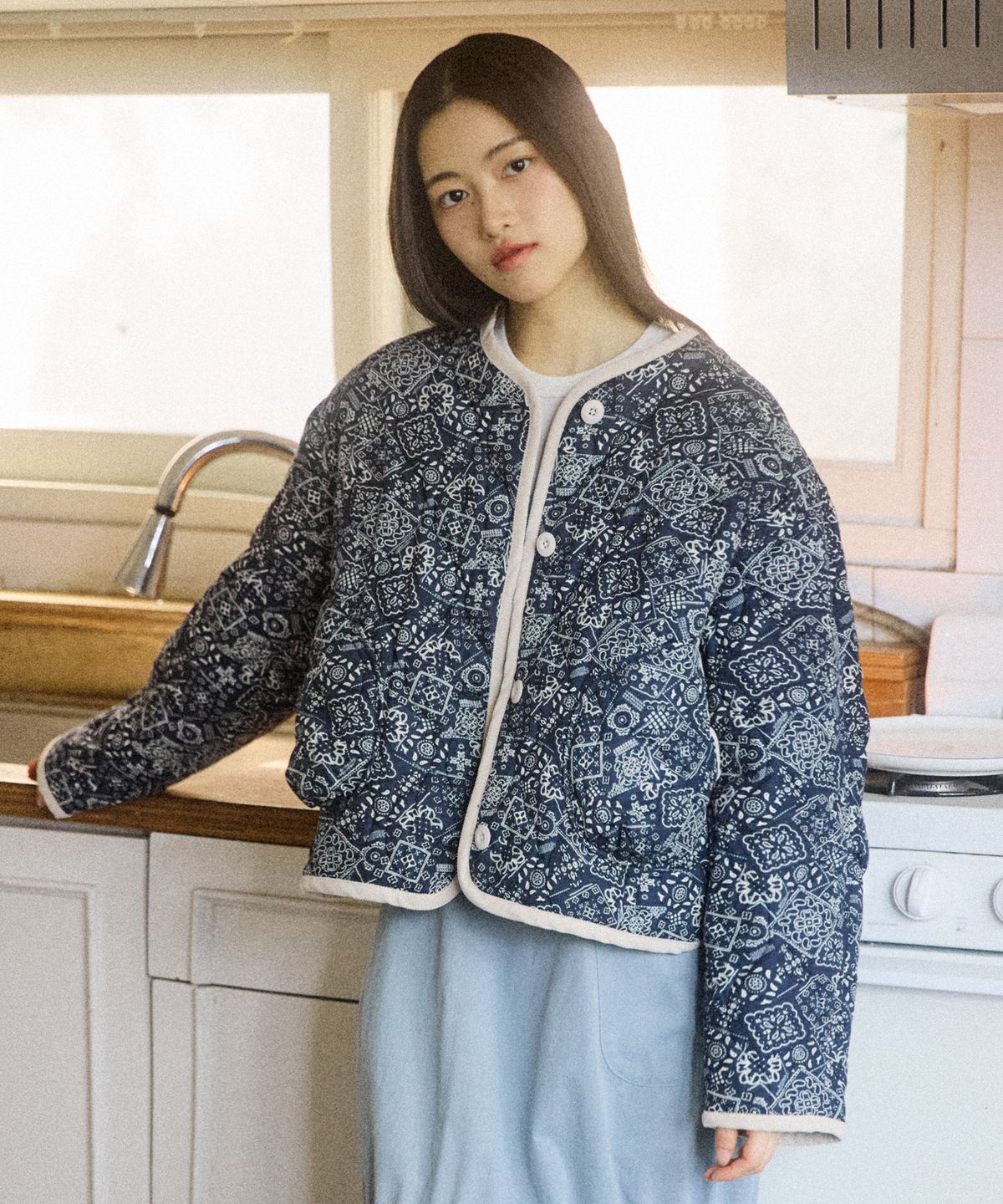 데님 팬츠와 함께 꼬모니노즈 점퍼를 착용한 모델이 야외에서 걷고 있는 전신 모습