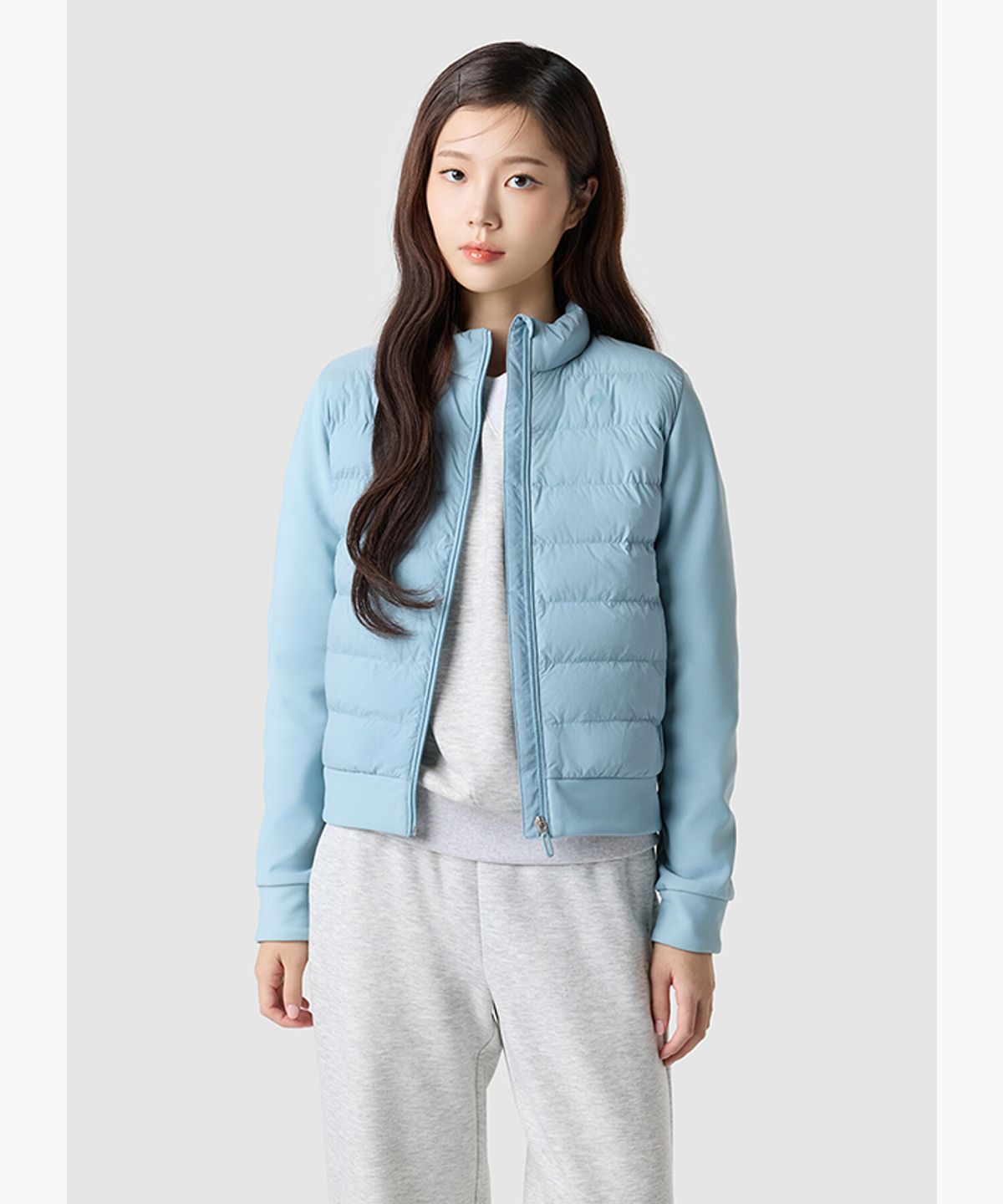 민트색 르꼬끄 경량 패딩 자켓이 깔끔하게 포장되어 침대 위에 놓여있는 모습