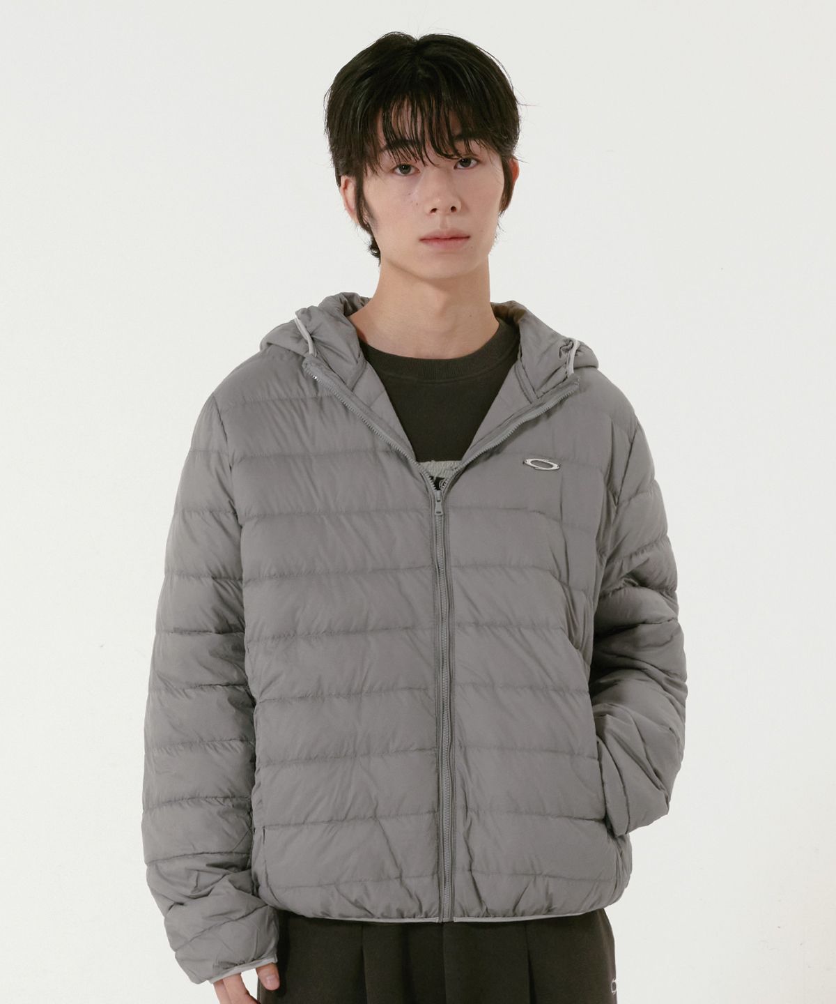 가방 옆자리에 가볍게 접어서 넣어둔 그레이 색상 자켓 모습