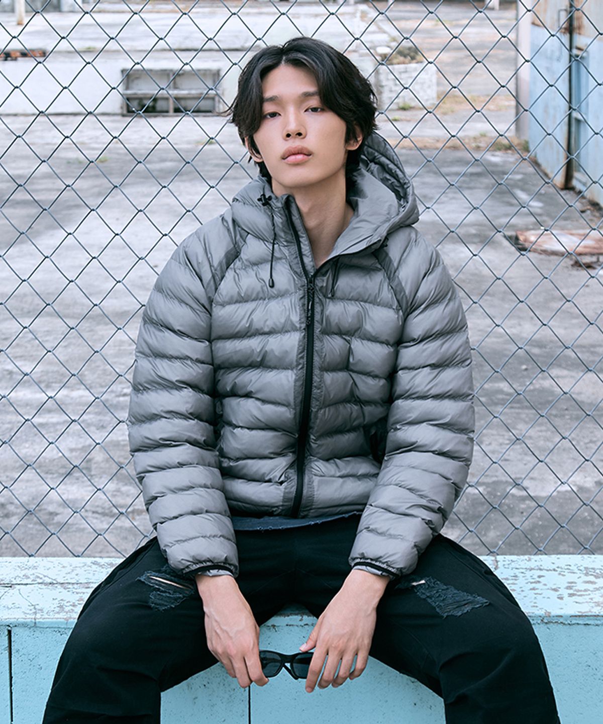 178cm 남성이 그레이 컬러 볼패딩을 입고 야외에서 활동적인 포즈를 취하고 있는 전신 샷