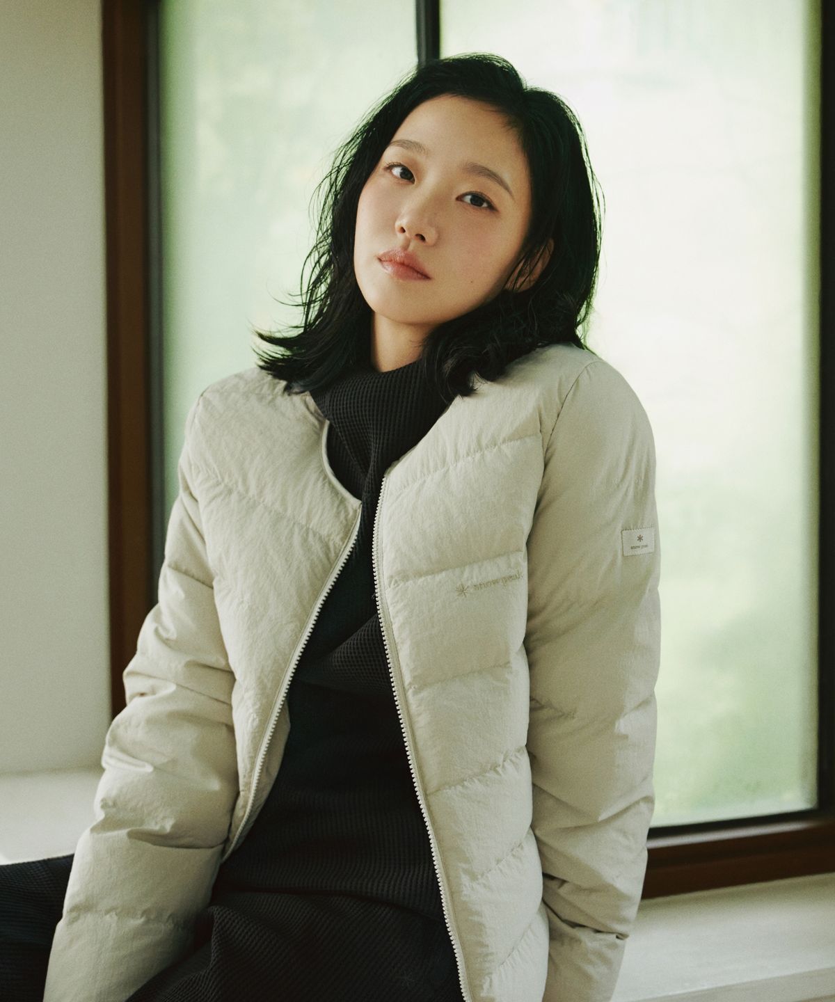 자켓의 정교한 로고 자수와 겉감의 고급스러운 무광 텍스처를 보여주는 근접 사진
