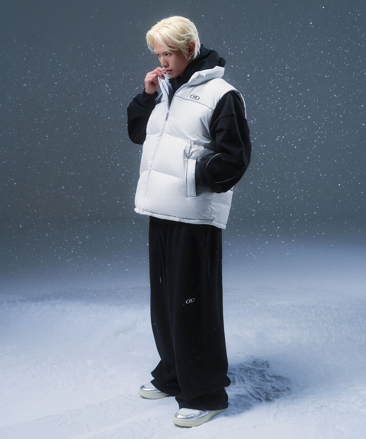 높게 올라온 넥 라인 지퍼를 끝까지 채우고 턱을 살짝 가린 힙한 무드의 클로즈업 샷