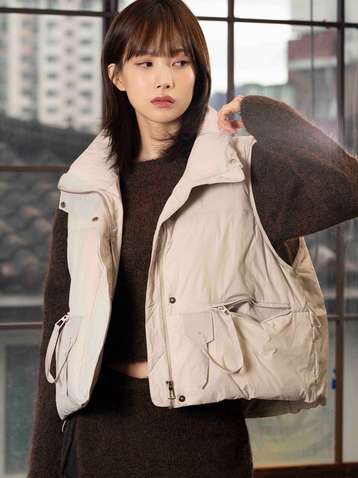 야외 공원에서 벤치에 앉아 패딩 베스트를 입고 편하게 활동하는 자연스러운 모습