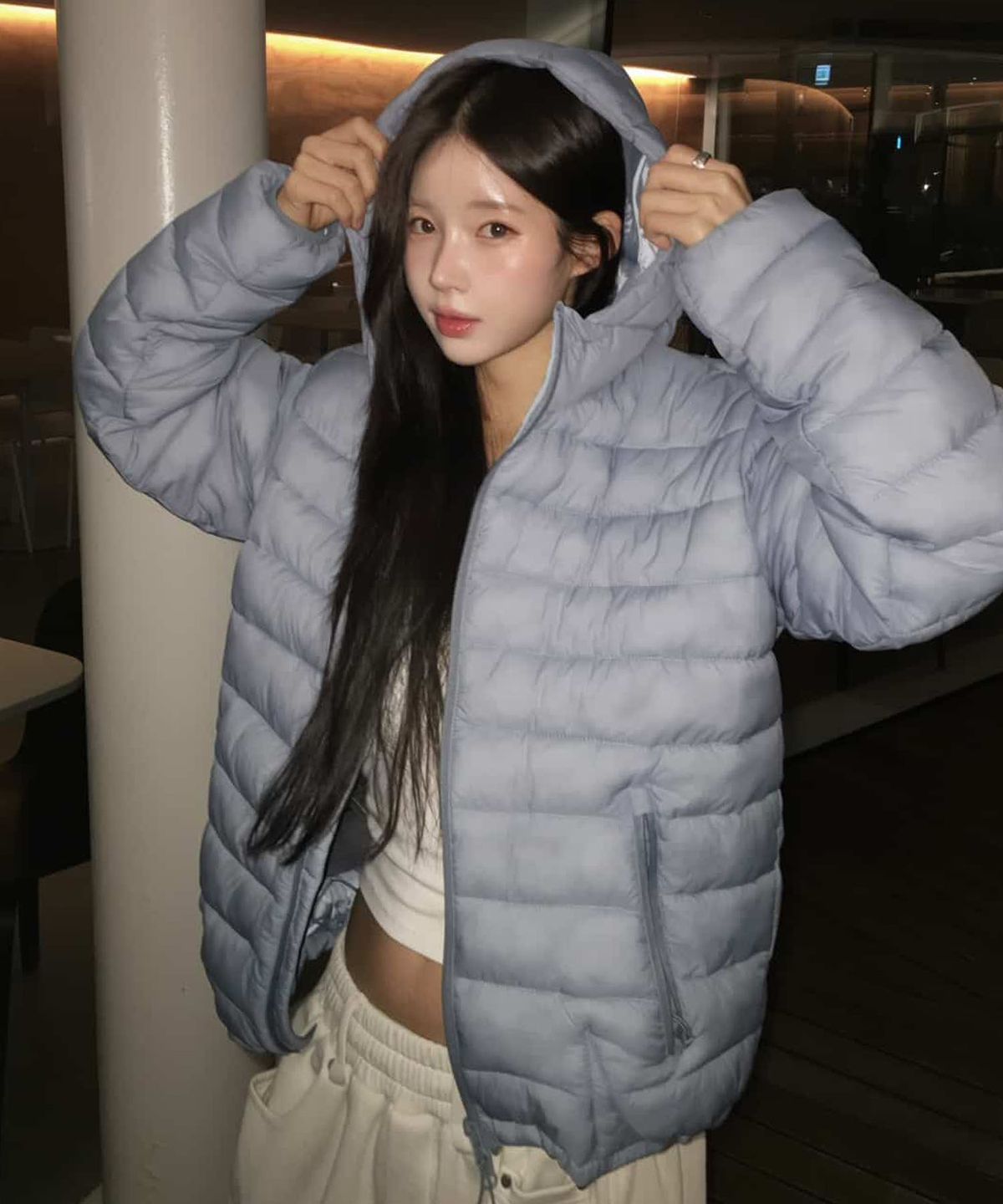 패딩 후드를 쓰고 야외에서 가볍게 산책하며 활동적인 느낌을 주는 뒷모습 사진