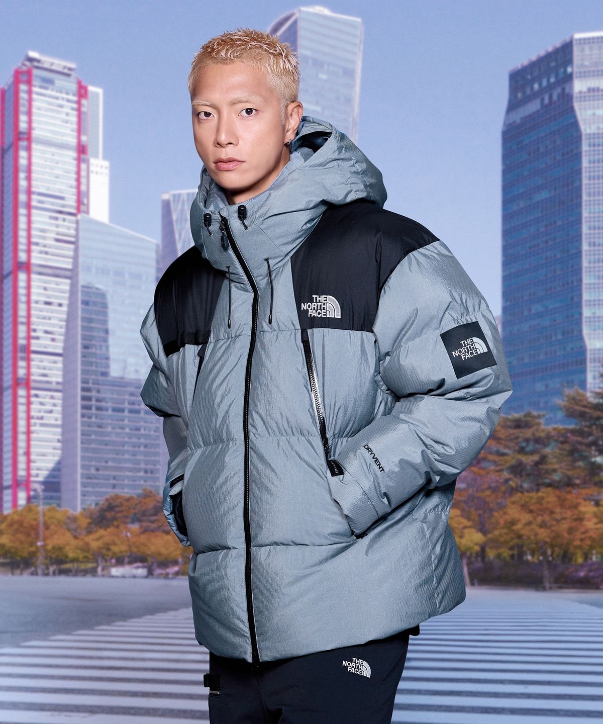 깔끔한 그레이 컬러의 노스페이스 라인 엑스 다운 자켓이 거실 조명 아래 놓여 있는 모습